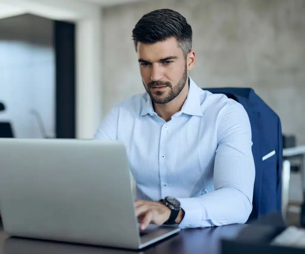 Profissional utilizando um notebook em ambiente de escritório, representando o uso da Jettax para automação fiscal, captura de notas e gestão de impostos.
