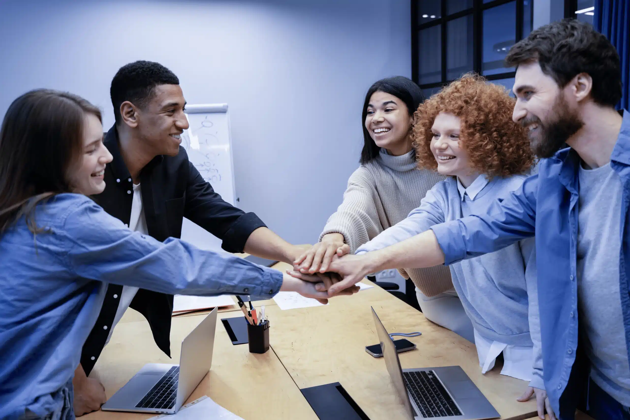 Equipe unindo as mãos em reunião de colaboração