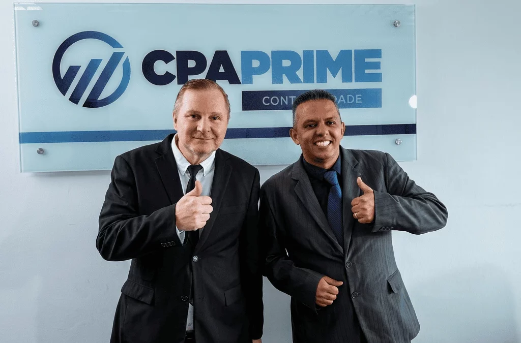 Dois profissionais da CPA Prime Contabilidade sorrindo e sinalizando positivo com o logo ao fundo, pela parceria.