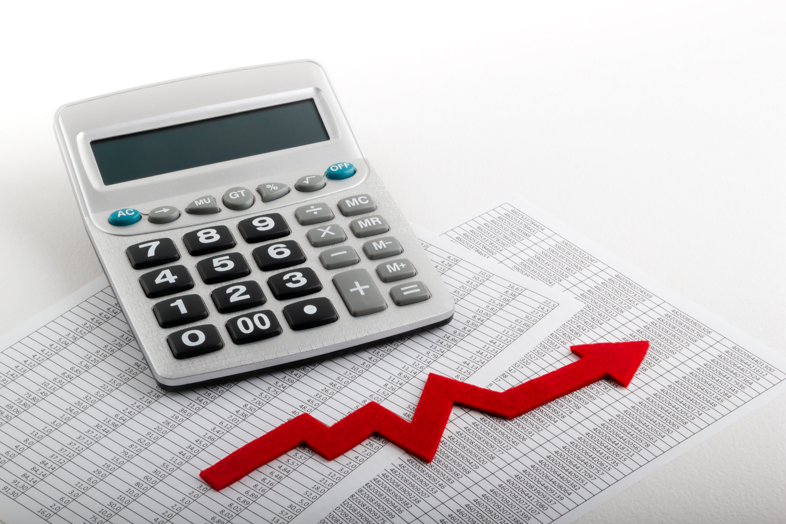 Calculadora sobre planilhas de números com seta vermelha em alta, representando a alíquota da CBS em 2027